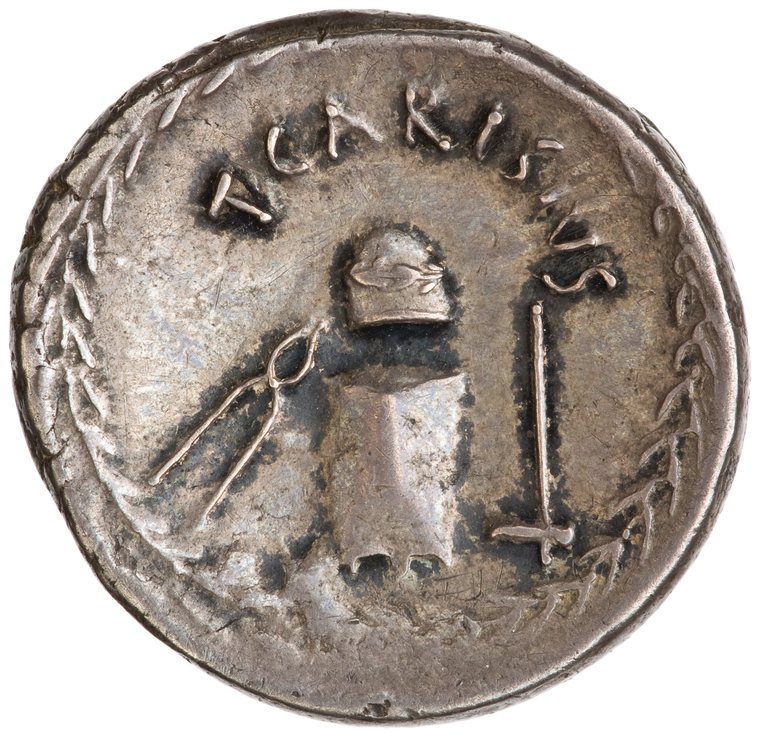 Reverse of the denarius of T. Carisius: anvil die with garlanded punch die above, tongs at left, hammer at right, within a laurel wreath, legend T CARISIVS.